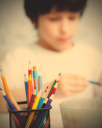colored pencils for drawing in pencil holders and the child on background.の写真素材