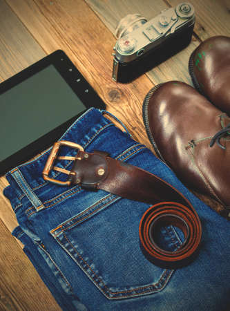 traveler set with a leather belt, digitizer, rangefinder camera, blue jeans and brown boots.の写真素材