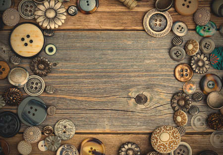 placer of vintage buttons with copy space on textured old boards of aged table.の写真素材