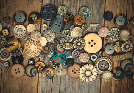 set of vintage buttons on aged table. close up.の写真素材