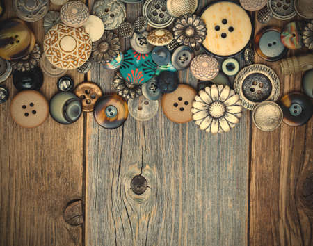 set of vintage buttons on aged boards surface. close up.の写真素材