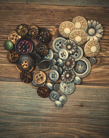 Heart from vintage classical buttons on the old textured boards.