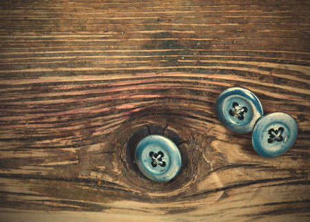 vintage buttons on the aged textured boards of the old tailor table.の写真素材