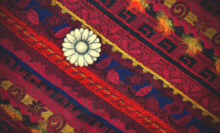 still life, vintage varicolored tape with embroidered ornaments and three old buttons.の写真素材