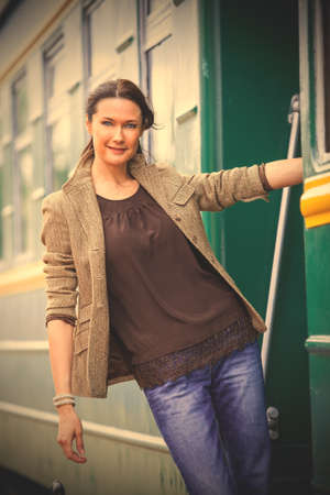 smiling beautiful middle-aged woman on the steps of the passenger carriage.  image filter retro...