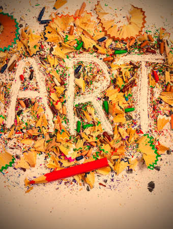 art word on the background of colored pencil shavings on the white.  image retro style