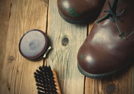 vintage still life with aged brown boots, shoe polish and shoe brush.の写真素材