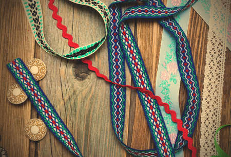 lace, ribbons, tape and buttons on the old tailoring table.の写真素材