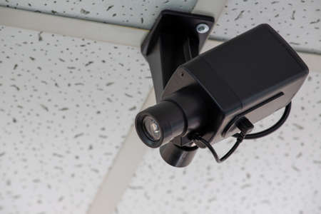 black surveillance camera on the ceilingの写真素材