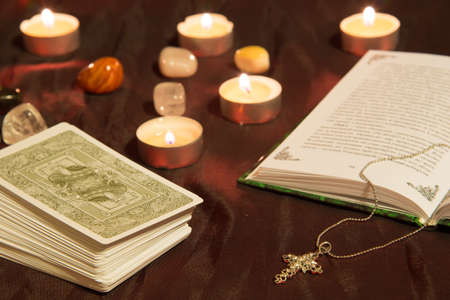 Moscow, Russia - December 4, 2016: Tarot card deck with book, cross and candles. Esoteric backgroundのeditorial素材