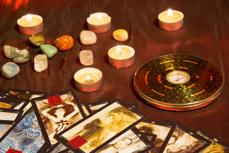 Moscow, Russia - December 4, 2016: Chinese magnetic compass - Luopan. Tarot cards, candles and...