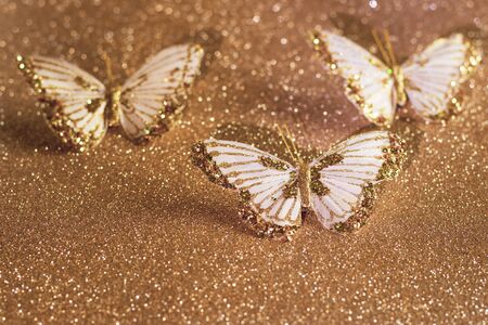 Sparkly gold and white butterflies on a sparkly gold glitter background.の写真素材