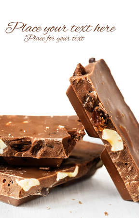 Stack of milk chocolate bars with nuts and raisins with a place for textの写真素材