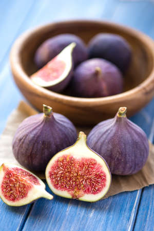 Group of figs in a bowl and on rustic blue wooden table