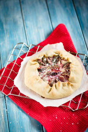 Christmas fig galette with cream cheese and honey on a metal rackの写真素材