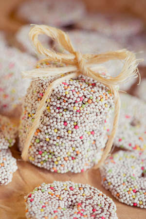 Stack of sprinkled holiday cookies tied together with a decorative ropeの写真素材
