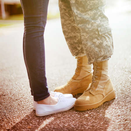 Young military couple kissing each other, homecoming concept, warm orange toning appliedの写真素材