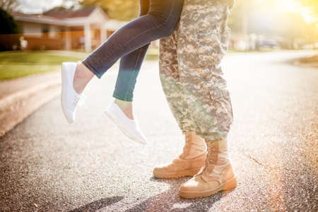 Young military couple kissing each other, homecoming concept, warm orange toning appliedの写真素材