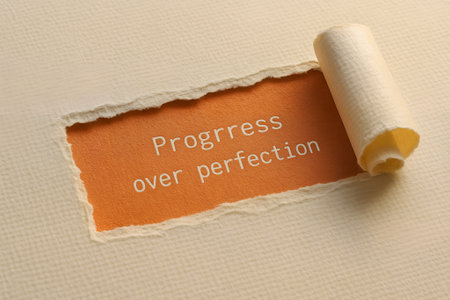 Torn Paper Note âProgress Over Perfectionâ â Motivational Quote Design on Beige Backgroundの素材