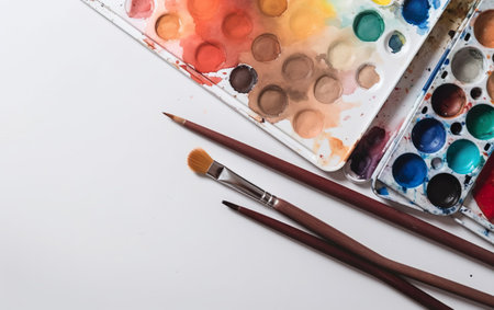 Set of watercolor paints and brushes on white background, top viewの素材