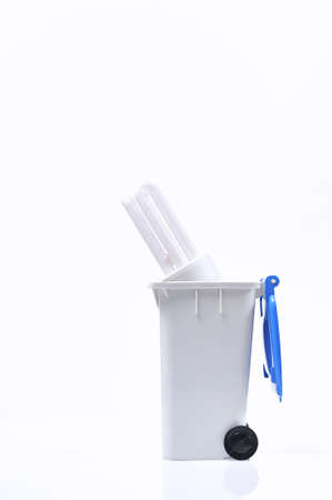 Energy efficient light bulb into a recycling bin.の写真素材