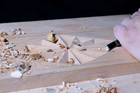 Working with carpenter tools to carve wood 