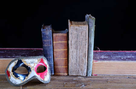 Carnival mask and old books in the table の写真素材