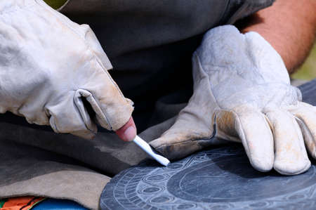 Artisan carved a slate in medieval market.