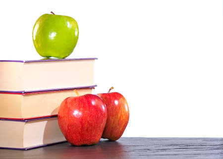 Three apples and three books on a table.の写真素材