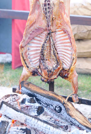 Entire Roasted Lamb on a Spit over open Fireの写真素材