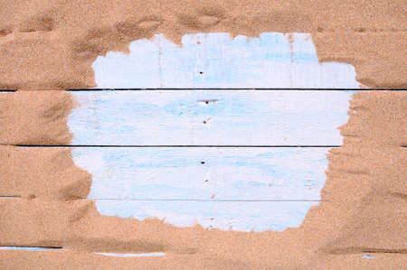 Blue wood surrounded by sand on the beach with space for text entryの写真素材