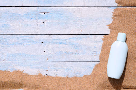 Jar of sunscreen on the beach sand.の写真素材