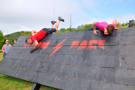 OVIEDO, SPAIN - MAY 9: Storm Race, an extreme obstacle course in May 9, 2015 in Oviedo, Spain. Runners jumping a wooden wall.のeditorial素材