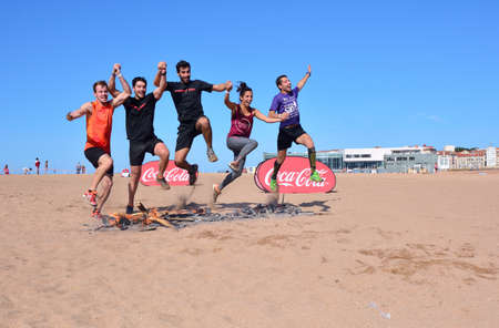 GIJON, SPAIN - SEPTEMBER 19: Storm Race, an extreme obstacle course in September 19, 2015 in Gijon, Spain. Runners jumping a barrier of fire.のeditorial素材