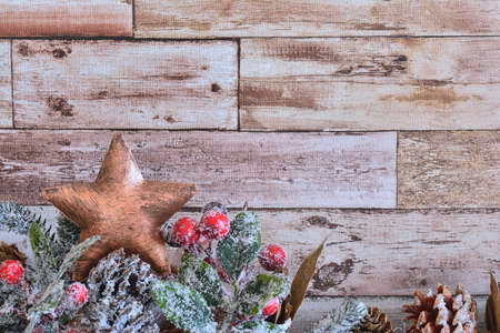 Close up of decorative Christmas star with fir branch with cones powdered with snowflakes on wooden backgroundの写真素材
