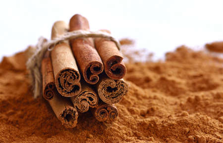 Close-up of powdered cinnamon with sticks on table