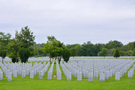 ELWOOD, ILLINOIS / USA - JULY 16: A small American flag honors the gravesite of World War II veterans and Vietnam veterans at Abraham Lincoln National Cemetery on July 16, 2017 in Elwood, Illinois.のeditorial素材