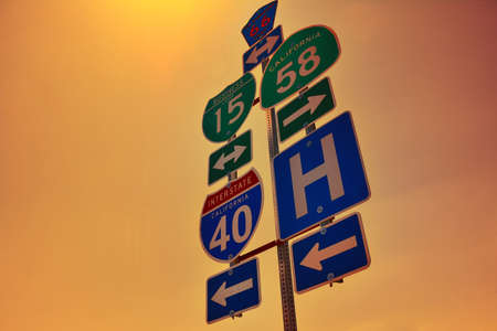 Interstate 40 road signs with dawn lights on San Bernardino county, California.の写真素材