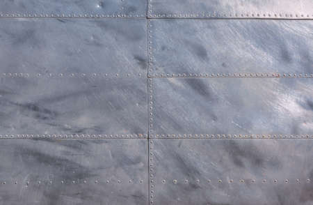 Airplane fuselage silver metal texture with rivets. Useful as background for design works.の写真素材
