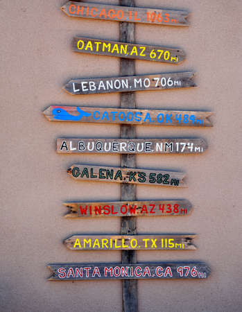 Wooden pole pointing the distance in miles to different cities through Route 66 from Chicago to Los...