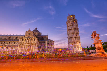 Pisa, Italy - July 8, 2018: Piazza dei miracoli, with the Basilica and the Leaning Tower, Pisa, Italy. Colored lights of street vendorsのeditorial素材