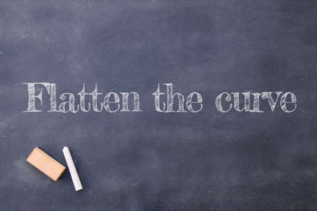Blackboard with Flatten the Curve about coronavirus pandemic, Covid 19.の写真素材
