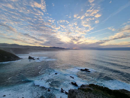 wonderful sunset on the coast with colored sky and conforming clouds.の写真素材