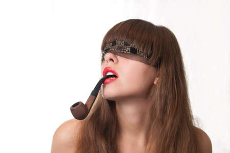 The beautiful girl blindfold and a pipe in lips