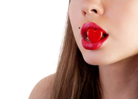 Mouth of the young woman with heart clamped in lips, on a white backgroundの写真素材