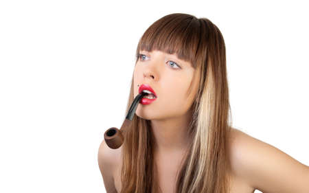 The beautiful young woman with a pipe in lipsの写真素材
