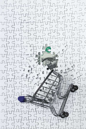 Side Shopping cart full of jigsaw puzzle on money dollar background, Business solution concept ,key for successの写真素材