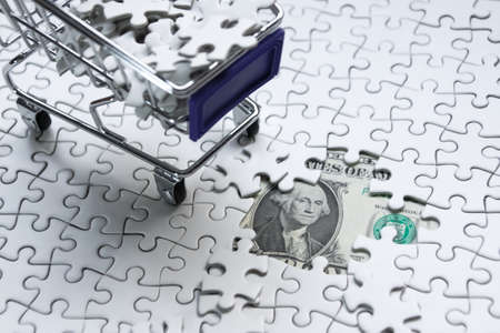 Shopping cart full of jigsaw puzzle on money dollar background, Business solution concept ,key for successの写真素材