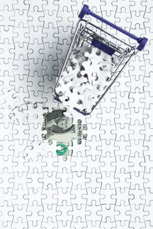 Shopping cart full of jigsaw puzzle on money dollar background, Business solution concept ,key for successの写真素材