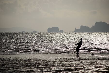 silhouette fisherman on the beachの写真素材